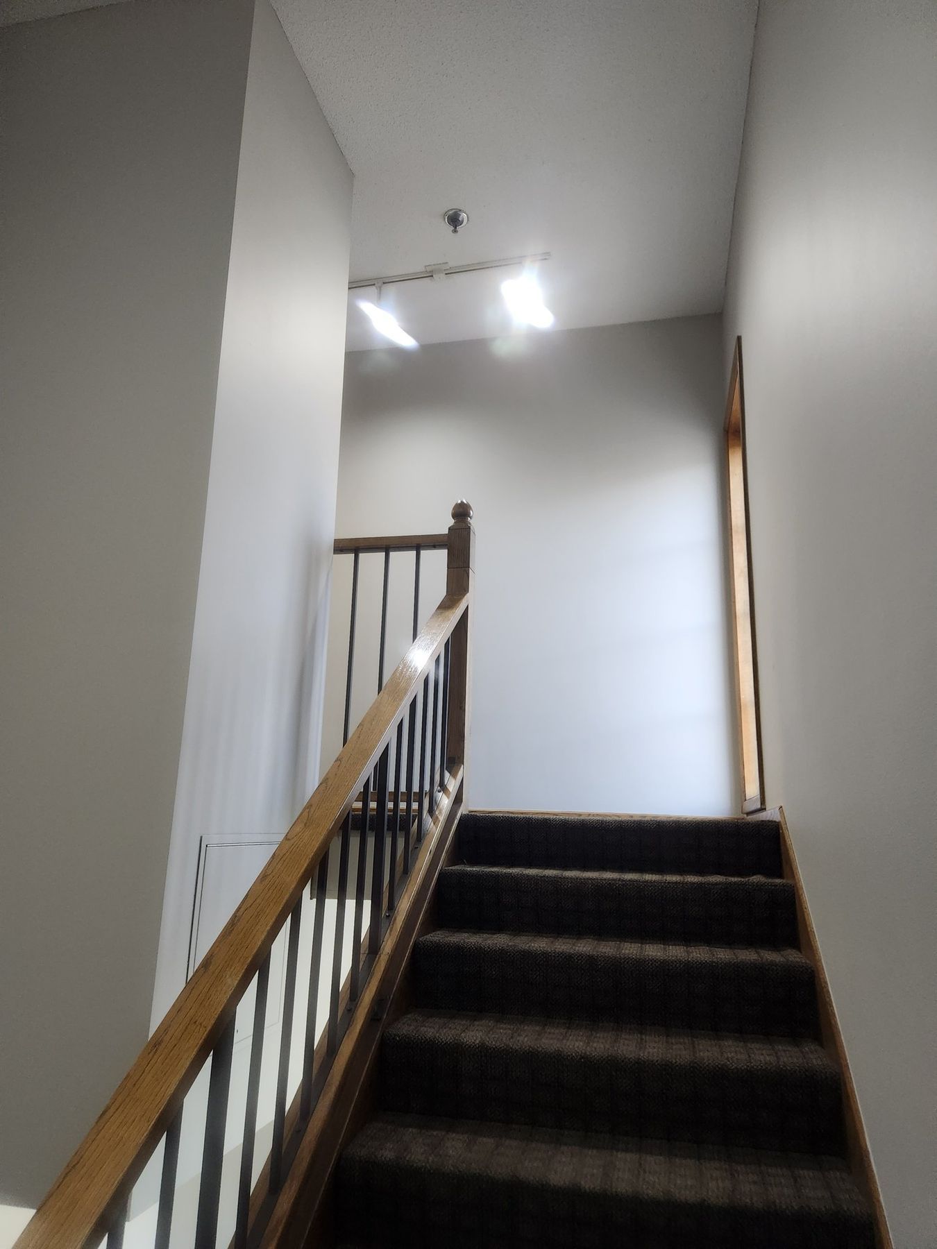 Stairwell walls repainted after wallpaper removal and water-stain repair