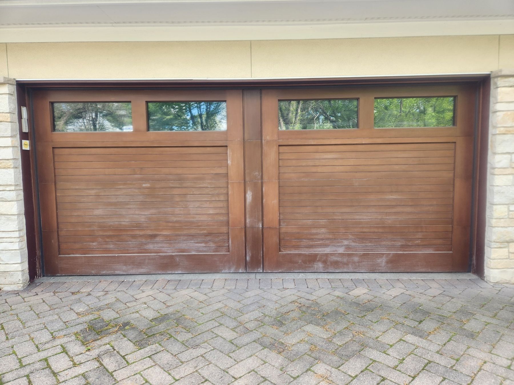 Before: weathered wood garage doors