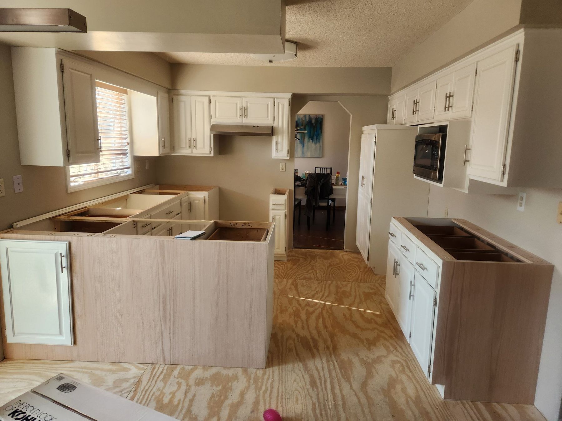 Before: kitchen mid-remodel, island and end panels in raw wood