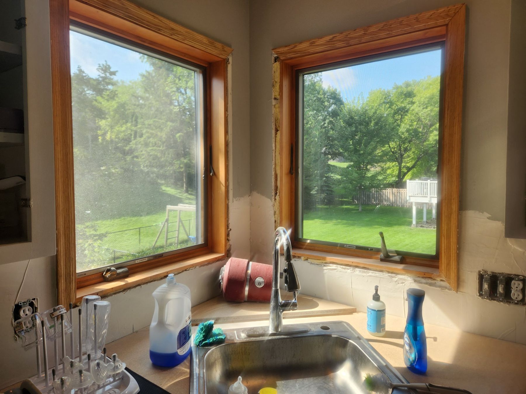 Before: golden oak casings around the kitchen windows
