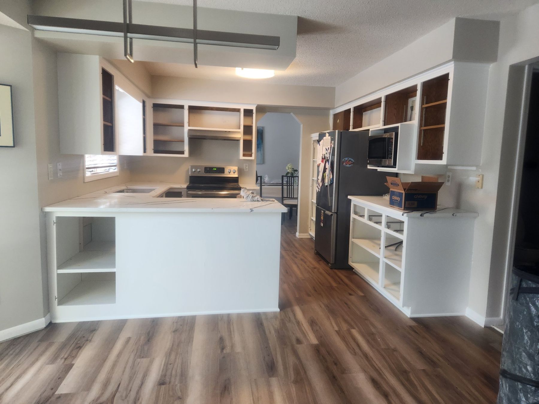 White re-sprayed kitchen cabinets and island over new flooring