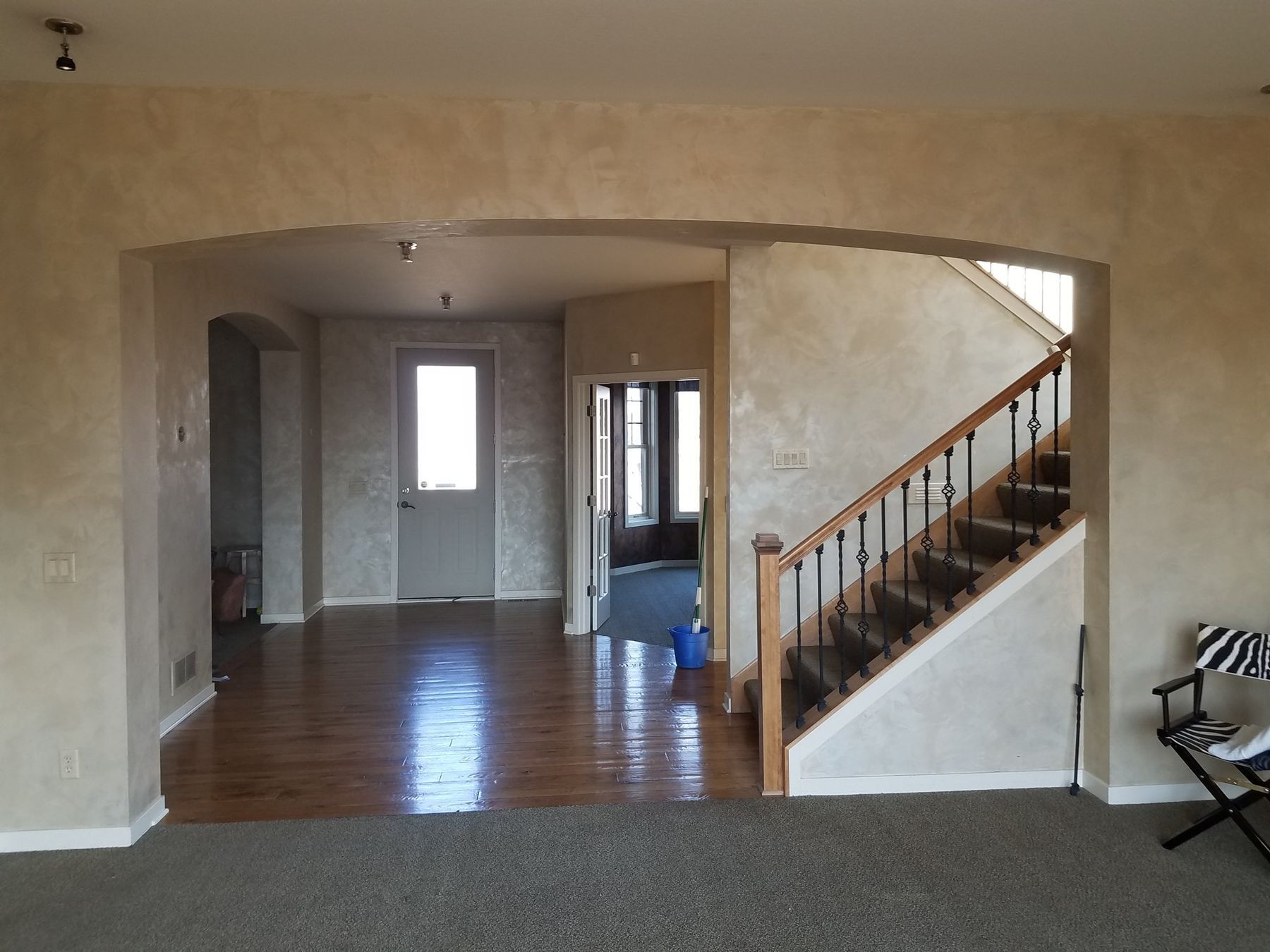 Before: Great room toward the stair: sponged faux finish to smooth bright white