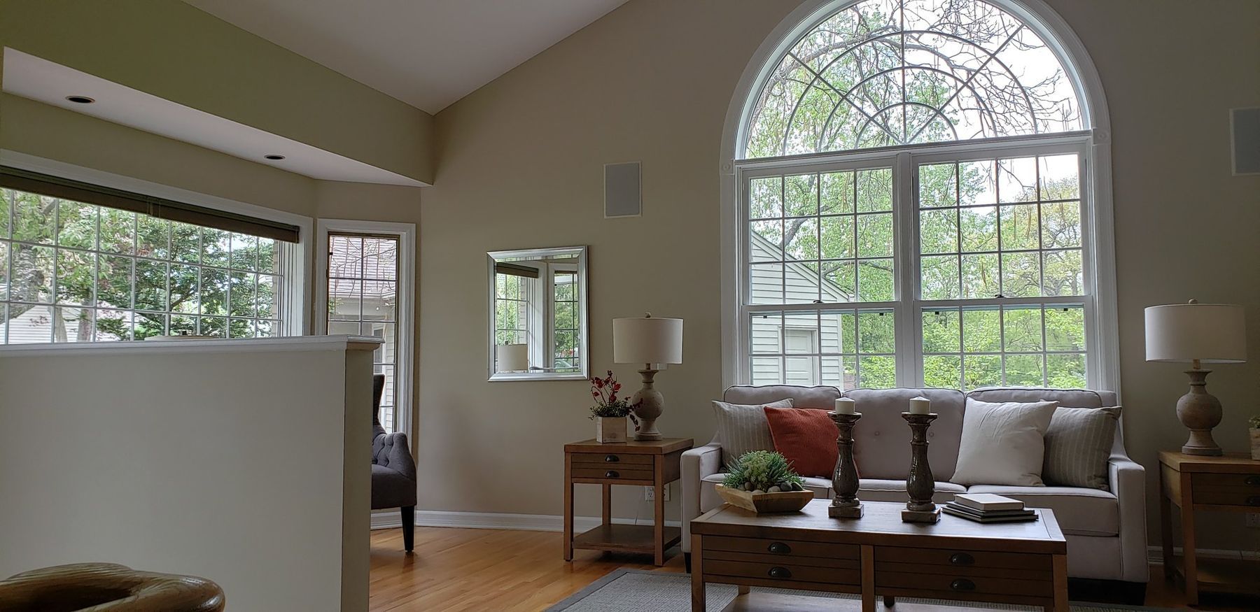 Living room with arched-top windows after the golden oak casings were painted white