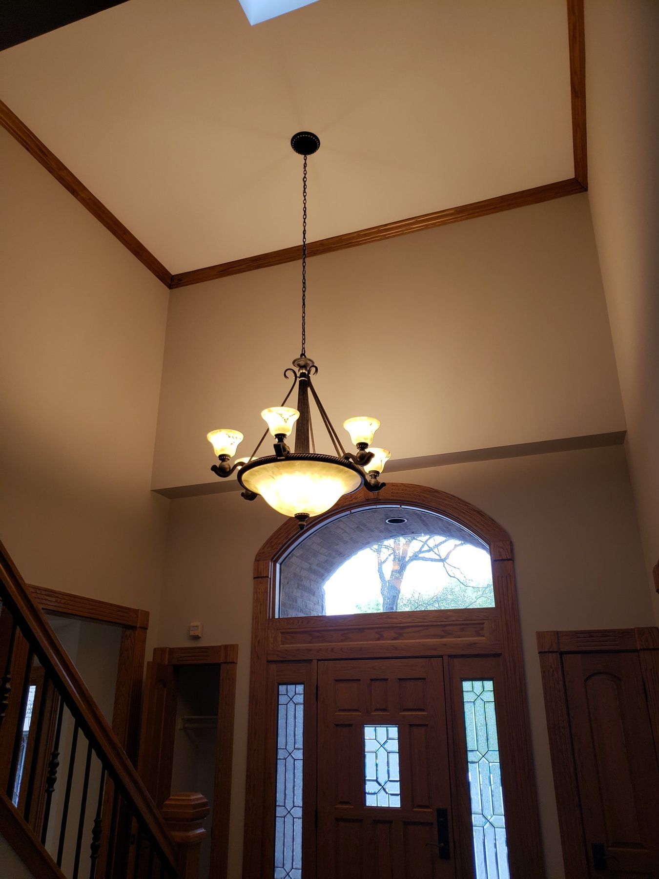 Before: two-story foyer with golden oak trim