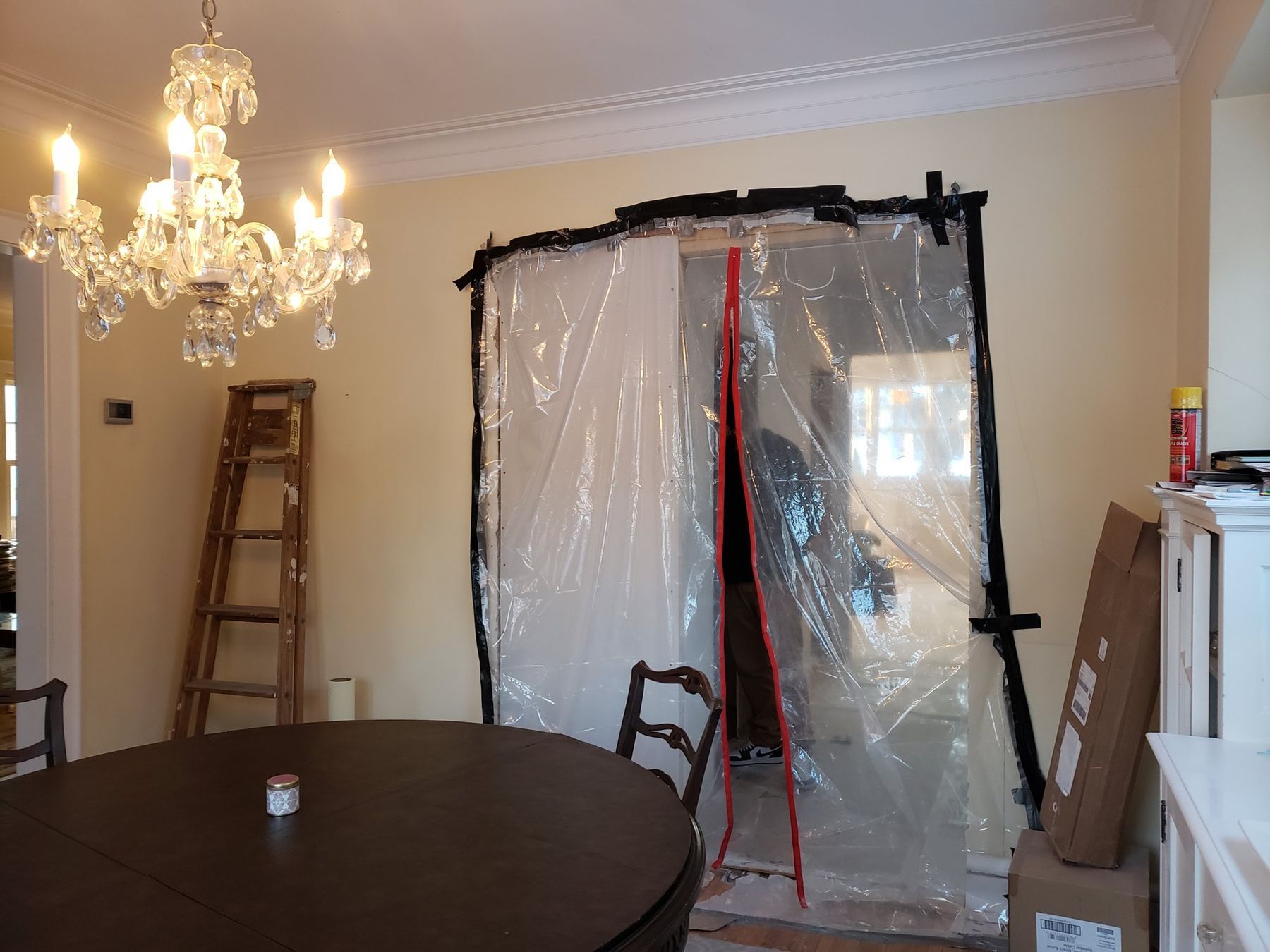 Zipwall plastic dust barrier with a zip door sealing off a work area from a dining room